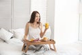 Beautiful young woman having breakfast on bed at home Royalty Free Stock Photo