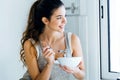 Beautiful young woman having breakfast in the kitchen. Royalty Free Stock Photo