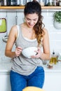 Beautiful young woman having breakfast in the kitchen. Royalty Free Stock Photo