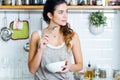 Beautiful young woman having breakfast in the kitchen. Royalty Free Stock Photo