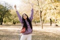 Beautiful young woman having fun, enjoying autumn weather in the park Royalty Free Stock Photo