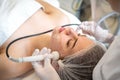 Beautiful young woman having Radio frequency skin tightening treatment in beauty clinic. Royalty Free Stock Photo