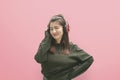 Beautiful young woman in headphones listening to music and dancing on pink background Royalty Free Stock Photo