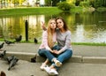 A beautiful young woman with her adult mother hugging on the background of the lake, on a summer day in the park. Royalty Free Stock Photo