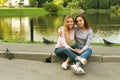 A beautiful young woman with her adult mother hugging on the background of the lake, on a summer day in the park. Royalty Free Stock Photo