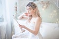 Beautiful young woman in her bedroom with a mirror. Bride`s morning or vintage boudoir