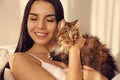 Beautiful young woman with her cute cat on bed. Fluffy pet Royalty Free Stock Photo