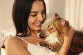 Beautiful young woman with her cute cat on bed. Fluffy pet Royalty Free Stock Photo