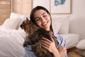 Beautiful young woman with her cute cat in bedroom Royalty Free Stock Photo