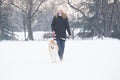 Beautiful young woman and her dog akita walking in park on snow Royalty Free Stock Photo