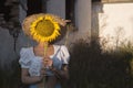 Beautiful young woman hiding behind a sunflower Royalty Free Stock Photo