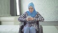 Beautiful young woman in hijab disabled person smiling, wheelchair, in apartment Royalty Free Stock Photo