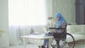 Beautiful young woman in hijab disabled person smiling, wheelchair, teleworking in the Internet Royalty Free Stock Photo