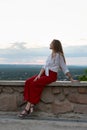 Beautiful young woman on hill is resting with view of nature. Vertical frame Royalty Free Stock Photo