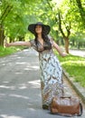 Beautiful young woman hitchhiking along a road with thumb up Royalty Free Stock Photo