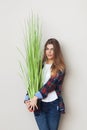 Beautiful young woman holding big green plant Royalty Free Stock Photo