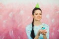Beautiful young woman holding birthday cupcake and making wish Royalty Free Stock Photo