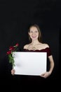 Beautiful young woman holding blank sign with red roses. Royalty Free Stock Photo