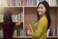 Beautiful young woman holding books in her hand and smiling at c Royalty Free Stock Photo