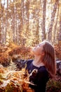 Beautiful young woman holding a bunch of autumn leaves, romantic dreaming mood, fall walking, relax time in the forest Royalty Free Stock Photo