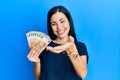 Beautiful young woman holding bunch of 50 euro banknotes smiling cheerful offering palm hand giving assistance and acceptance Royalty Free Stock Photo