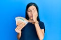 Beautiful young woman holding bunch of 50 euro banknotes yawning tired covering half face, eye and mouth with hand Royalty Free Stock Photo