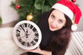 beautiful young woman holding clock which are displaying 5 minutes to midnight Royalty Free Stock Photo