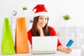 Beautiful young woman holding credit card with laptop. Christmas Royalty Free Stock Photo