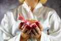 Beautiful young woman holding a cupcake with a colored candle in a silk robe. Royalty Free Stock Photo