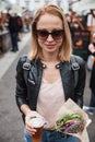 Beautiful young woman holding delicious organic salmon vegetarian burger and homebrewed IPA beer on open air beer an