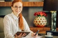 Beautiful young woman holding digital tablet and looking at camera with smile Royalty Free Stock Photo