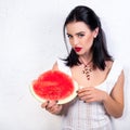 Beautiful young woman holding and eating slice of ripe red fresh juicy tasty watermelon