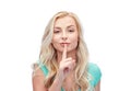 Beautiful young woman holding finger at her lips Royalty Free Stock Photo