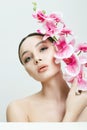 Beautiful young Woman holding  Flowers. Beauty Portrait of Girl with Orchid flower Royalty Free Stock Photo