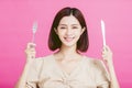 Beautiful young woman holding a fork and  table knife with tasting food concept Royalty Free Stock Photo