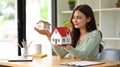 Beautiful young woman holding house model, planning for real estate investment Royalty Free Stock Photo