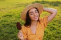 Beautiful young woman holding ice cream glazed in chocolate outdoors Royalty Free Stock Photo