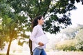 Beautiful young woman holding laptop computer and walking at public park in the morning,Happy and smiling Royalty Free Stock Photo