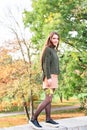 Young woman holding maple leaf in hand outdoor