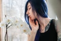 Beautiful young woman holding potted plant and smiling at camera  on grey Royalty Free Stock Photo