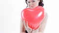 Beautiful young woman holding red balloon heart. Royalty Free Stock Photo