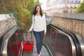 Beautiful woman with suitcase going up escalator Royalty Free Stock Photo