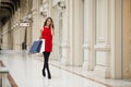 Beautiful young woman holding shopping bags walking in the shop