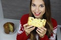 Beautiful young woman holding a slice of Panettone on Christmas holiday. Close up from above looking to the camera. Copy space Royalty Free Stock Photo