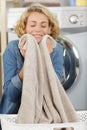 beautiful young woman holding and smelling clean towels at home Royalty Free Stock Photo