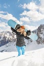 Beautiful young woman holding snowboard on her shoulders. Snowboarder or snowboarding concept at sunny day Royalty Free Stock Photo