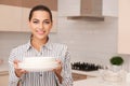 Beautiful young woman holding stack of clean dishes Royalty Free Stock Photo