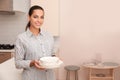 Beautiful young woman holding stack of clean dishes Royalty Free Stock Photo