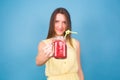 Beautiful young woman holding strawberry smoothie on blue background. Healthy organic drinks concept. People on a diet. Royalty Free Stock Photo