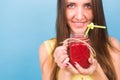 Beautiful young woman holding strawberry smoothie on blue background. Healthy organic drinks concept. People on a diet. Royalty Free Stock Photo